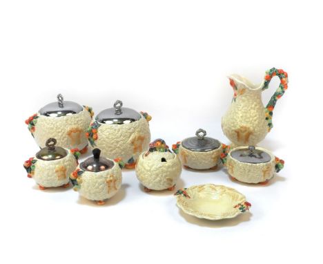 A collection of Clarice Cliff harvest ware pottery, including various jugs and biscuit barrels