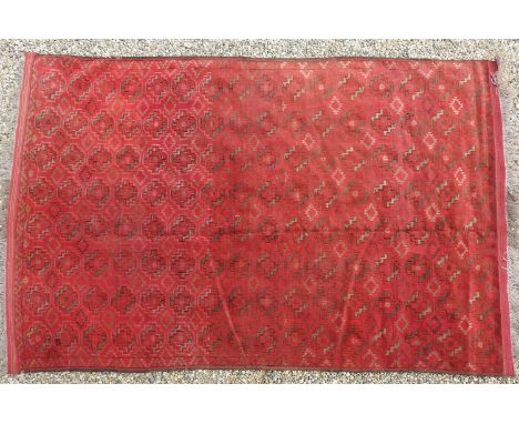 A large hand knotted Persian Bokhara carpet, the red fields with repeated elephant foot motifs, 318cm x 203cm