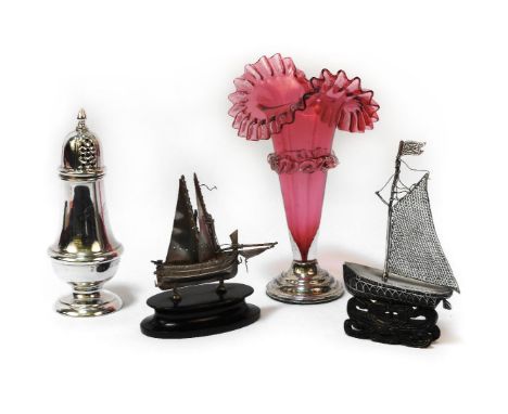 A silver sugar sifter, cranberry vase, and two eastern model boats. Tallest item 17cm