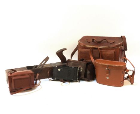 A collection of black planes, binoculars, Zeiss Ikon camera, and other accessories