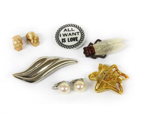 A collection of costume jewellery to include a Christian Lacroix white ceramic plaque brooch, with black lettering 'All I wan