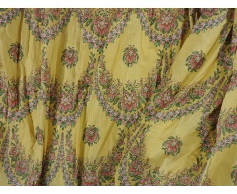 A pair of printed curtains, with floral garlands, on a yellow ground, 205cm high, with pelmets and tie backs