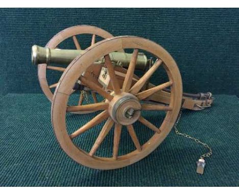 A miniature brass cannon on wooden carriage