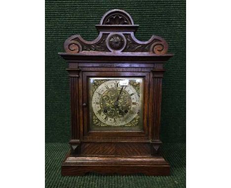 A Victorian carved oak eight day bracket clock with brass dial