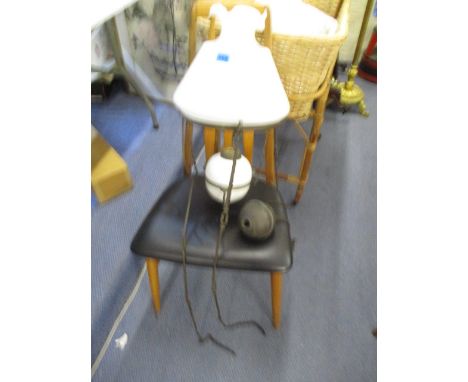 An early 20th century brass framed rise and fall oil lamp with a white glass shade