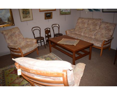 An Ercol sitting room suite, comprising: a three-seater sofa and a pair of armchairs, with elm frame.