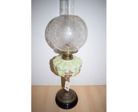 A Victorian brass oil lamp, with acid etched shade and opaque green glass reservoir with floral decoration, raised on circula