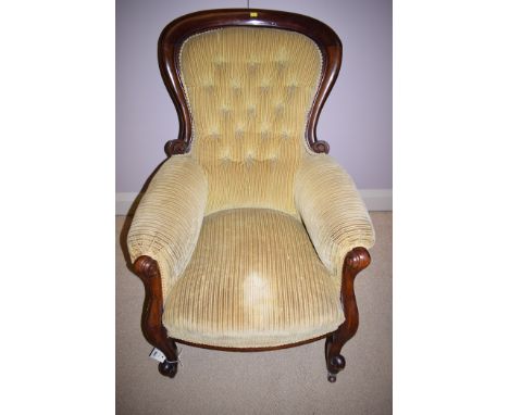 A Victorian mahogany framed button-back armchair, the seat upholstered in striped mustard coloured fabric, the cabriole legs 