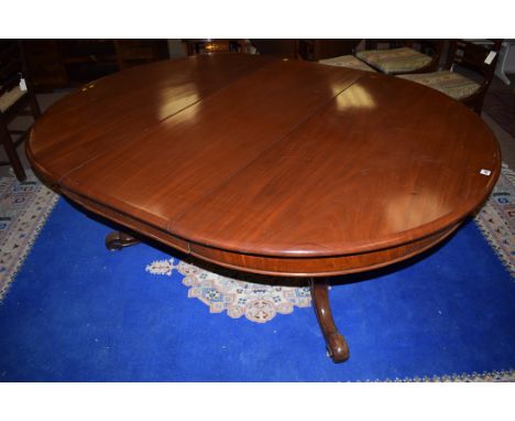 A Victorian mahogany extending dining table with one spare leaf, the turned column raised on splayed feet terminating in cera