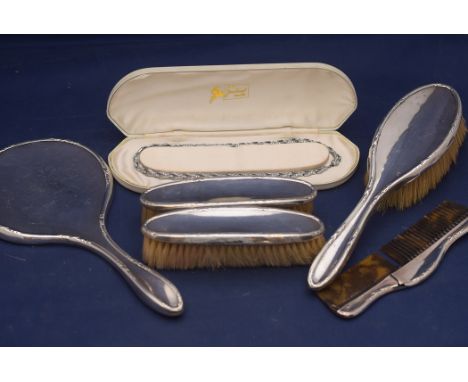 A George V silver dressing table set, by Walker & Hall, Sheffield 1918, comprising: hand mirror, hair brush, comb and clothes