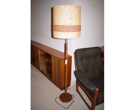 A c.1970 teak standard lamp, with leather and flax lampshade.