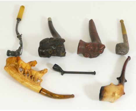 A Meerschaum pipe, carved with two horses, a carved briar pipe of a bearded gentleman and other pipes. 