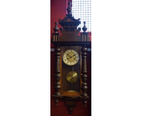 Early 20th century walnut cased Vienna type wall clock, the overhanging cornice with double height and shaped pediment with m