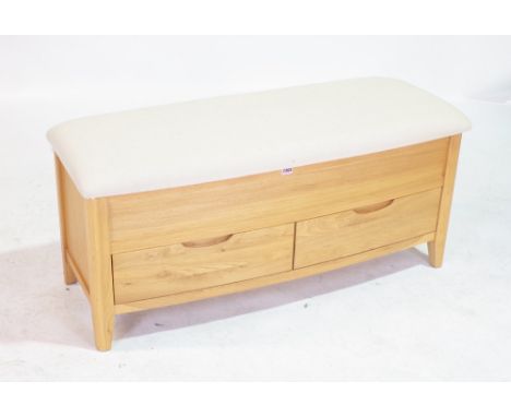 A MODERN OAK TRUNK WITH GREY UPHOLSTERED SEATOver two drawer base 113cm wide; 49cm high