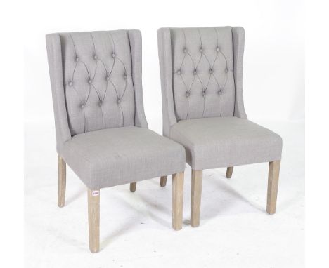 A PAIR OF MODERN HARDWOOD FRAMED WINGBACK SIDE CHAIRSWith grey button back upholstery 51cm wide; 97cm high