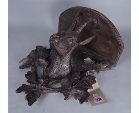AN EARLY 20TH CENTURY BLACK FOREST CARVED WALL SHELFWith carved chamois head decoration 33cm wide; 37cm high