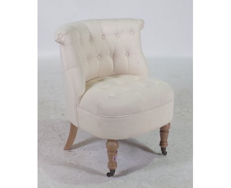 A MODERN BEECH FRAMED LOW ARMCHAIRWith white button back upholstery on turned supports 58cm wide; 81cm high
