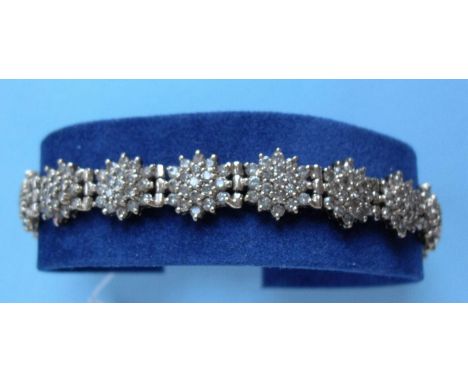 A gold and diamond bracelet comprising eighteen clusters of nineteen brilliant cut diamonds, (three hundred and forty in tota