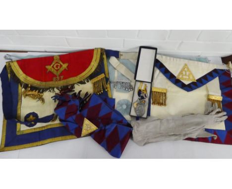 A collection of Masonic regalia to include three aprons, a sash and a gilt metal medal and a pewter medal, together with a co