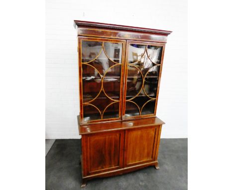 Late George III style mahogany inlaid bookcase, the rectangular top with dentil frieze over a pair of glazed doors with a she