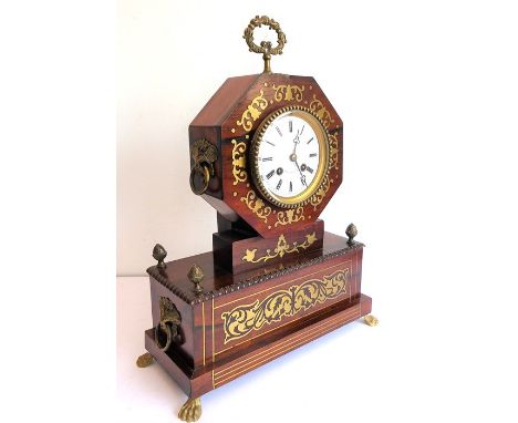 An early 19th century rosewood and brass inlaid eight-day mantle clock; the white-enamel dial with Roman numerals and signed 