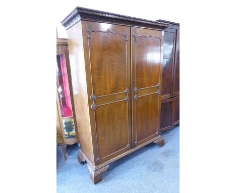 An&nbsp;early 20th century&nbsp;Chippendale-style two-door mahogany wardrobe; the gadrooned and dentil cornice carved with lu