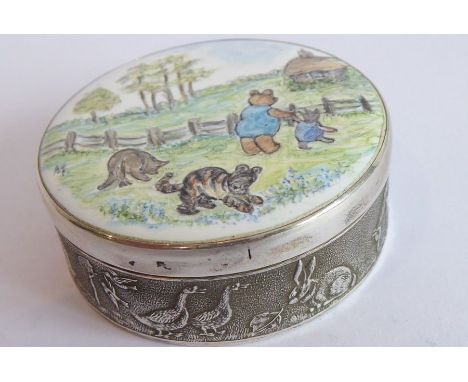 A circular silver and enamel box; the enamelled lid depicting Winnie the Pooh, Piglet, Tigger and Eeyore in the countryside, 