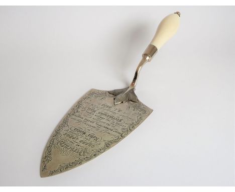 A late 19th century silver and ivory-handled presentation trowel; the script within the foliate scrolling-style engraving and