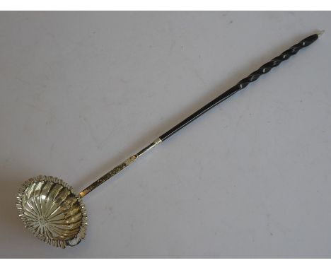 An early 19th century silver and whalebone toddy ladle; the scallop-edged bowl to the monogrammed shaft and turned whalebone 