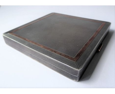 A silver square compact case by Dunhill, the exterior with engine-turned decoration and a yellow-coloured border and thumbpie