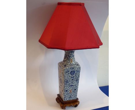 A Chinese porcelain vase (now as a lamp); the tapering triangular red silk lampshade with concave corners above the vase of s