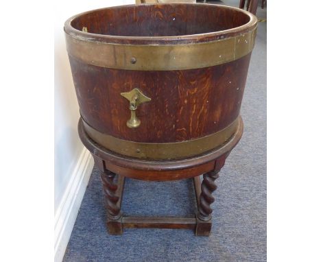 An early 20th century brass-bound oak planter/wine cooler; the cylindrical barrel with maker's label of 'RA Lister' and with 
