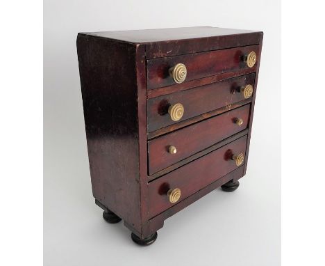 An early/mid-19th century mahogany caddy top apprentice chest; comprising four full-width graduated drawers, each with turned