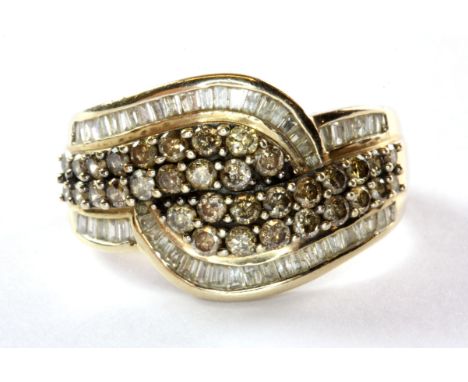 A 9ct (stamped 9kt) yellow gold crossover ring set with champagne brilliant cut and white baguette cut diamonds, (P).