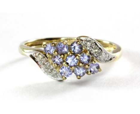A 9ct yellow gold tanzanite and diamond set cluster ring, (L.5).