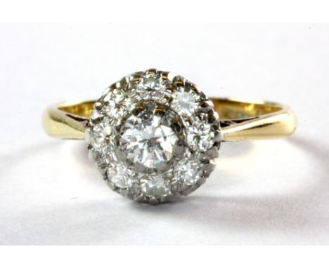 An 18ct and platinum (worn mark) yellow gold diamond set cluster ring, (N).