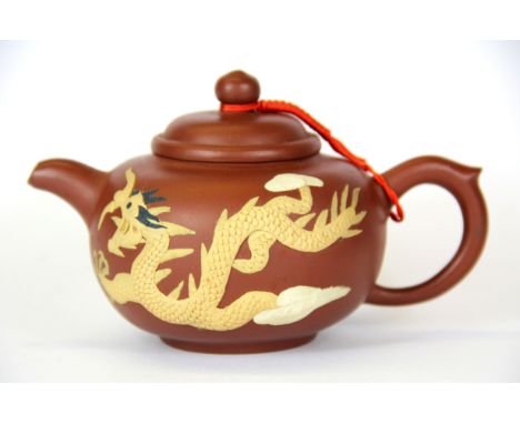 A Chinese terracotta teapot decorated with a dragon.