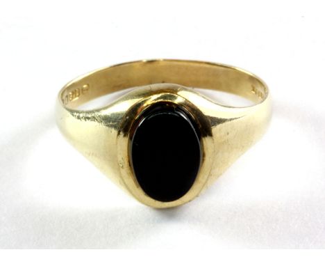 A 9ct yellow (stamped 375) gold onyx set ring, (J.5).