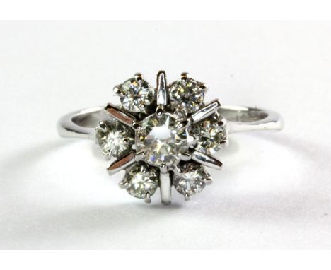 An 18ct (mark worn) white gold and diamond set cluster ring, (P.5).
