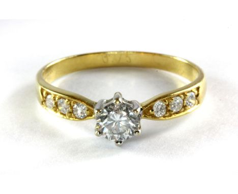 An 18ct (stamped 750) yellow gold diamond solitaire ring with diamond set shoulders, approx. .75ct, (T).