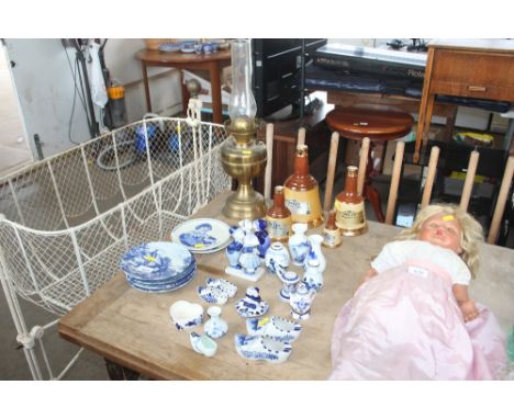 Three stoneware jugs; a brass oil lamp; Bell's scotch whisky decanters and various blue and white china to include Delft