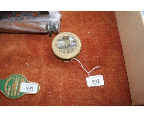 A reproduction brass compass (98)