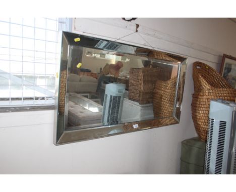 An unframed bevel edge wall mirror