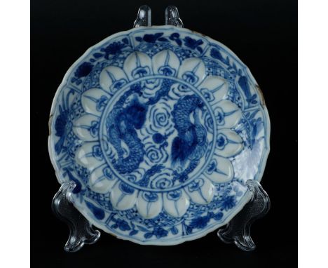A porcelain plate with two dragons competing for the flaming pearl, embossed with a lotus leaf rim. China, Kangxi.Diam.: 11,5
