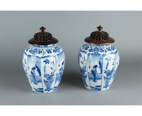 A pair of 18th century Delft vases with Kangxi decor in divisions. Both with wooden lid.H.: 29 cm. (incl. deksel). 