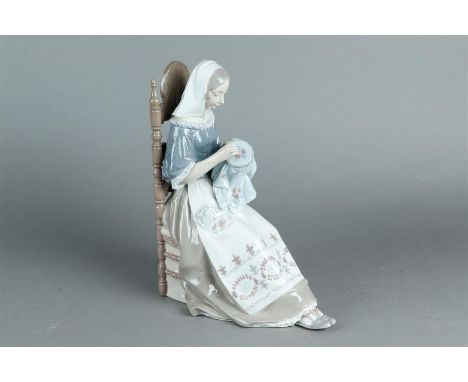  A porcelain group of a manual worker seated in a chair, marked Lladro. Spain, late 20th century.H.: 29 x B.: 23 cm.