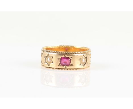 An 18ct yellow gold three stone ruby and split pearl ring, set with a central oval cut ruby flanked to either side with a spl