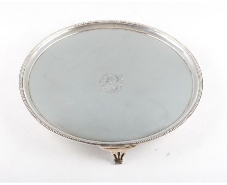 A George IV silver salver, the circular form raised on three leaf design feet, centrally engraved with monogram, hallmarked L