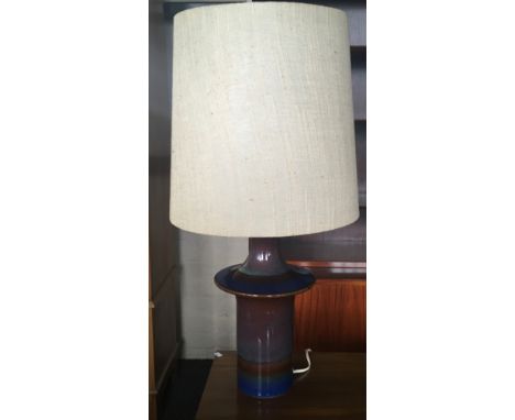 A blue and red soholm stento lamp with beige shade.