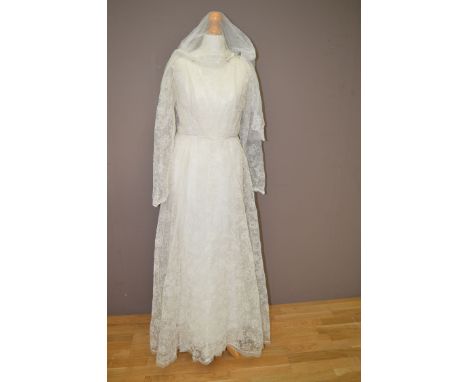 A 1960's/70's cream wedding dress, tulle and gauze, with embroidered effect floral decoration, faux pearl and diamante decora